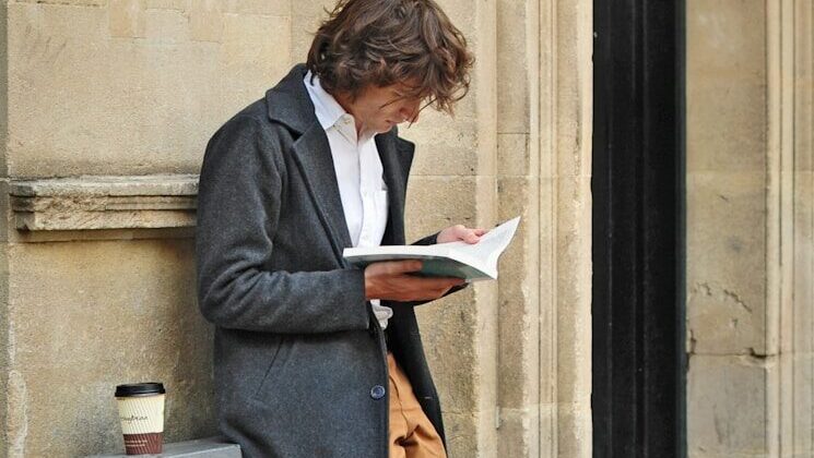 man sitting beside cup of coffee